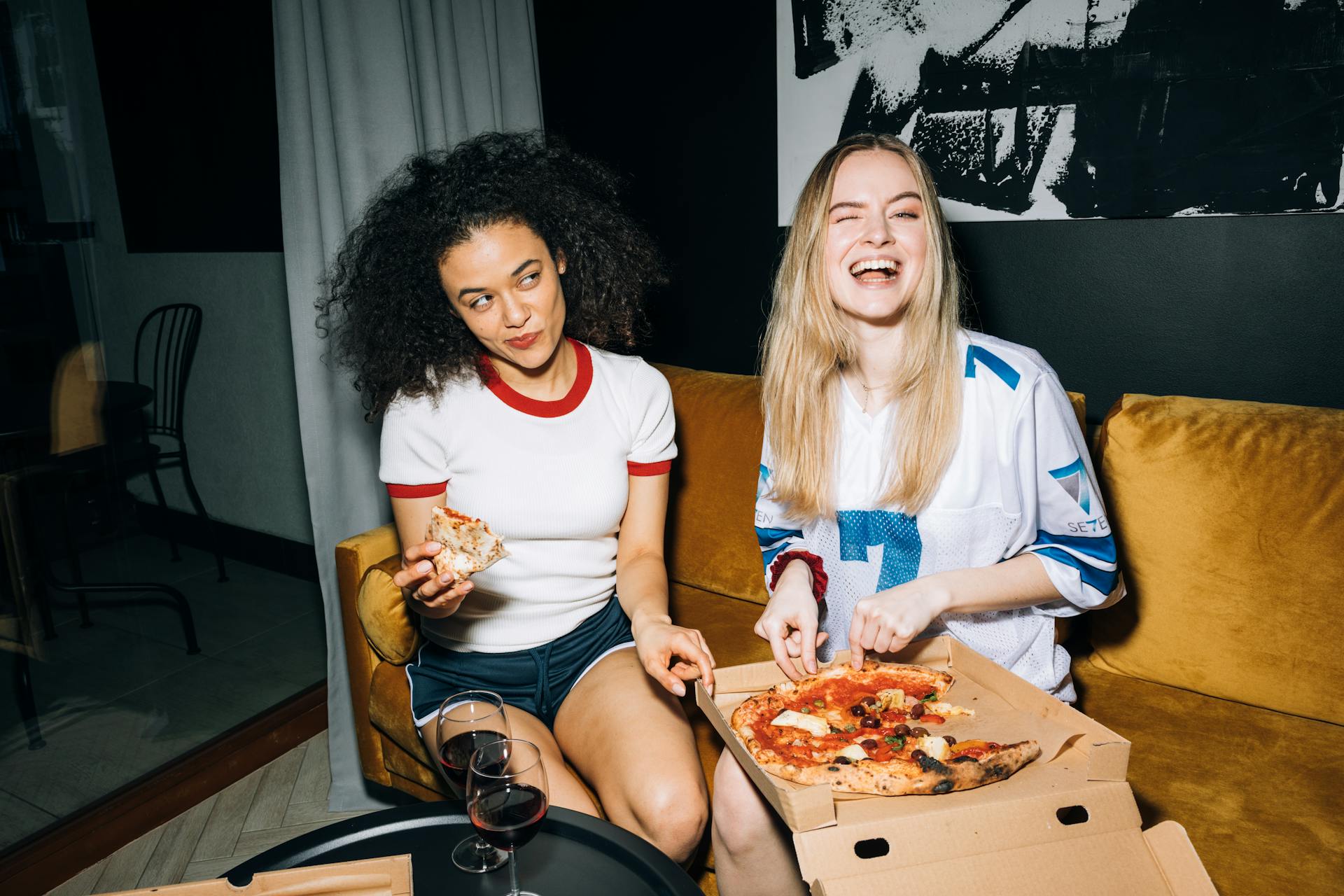 Two teenagers enjoying pizza